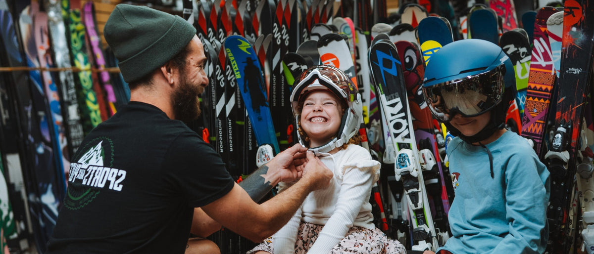 deux enfants essaient des casques de ski alpin